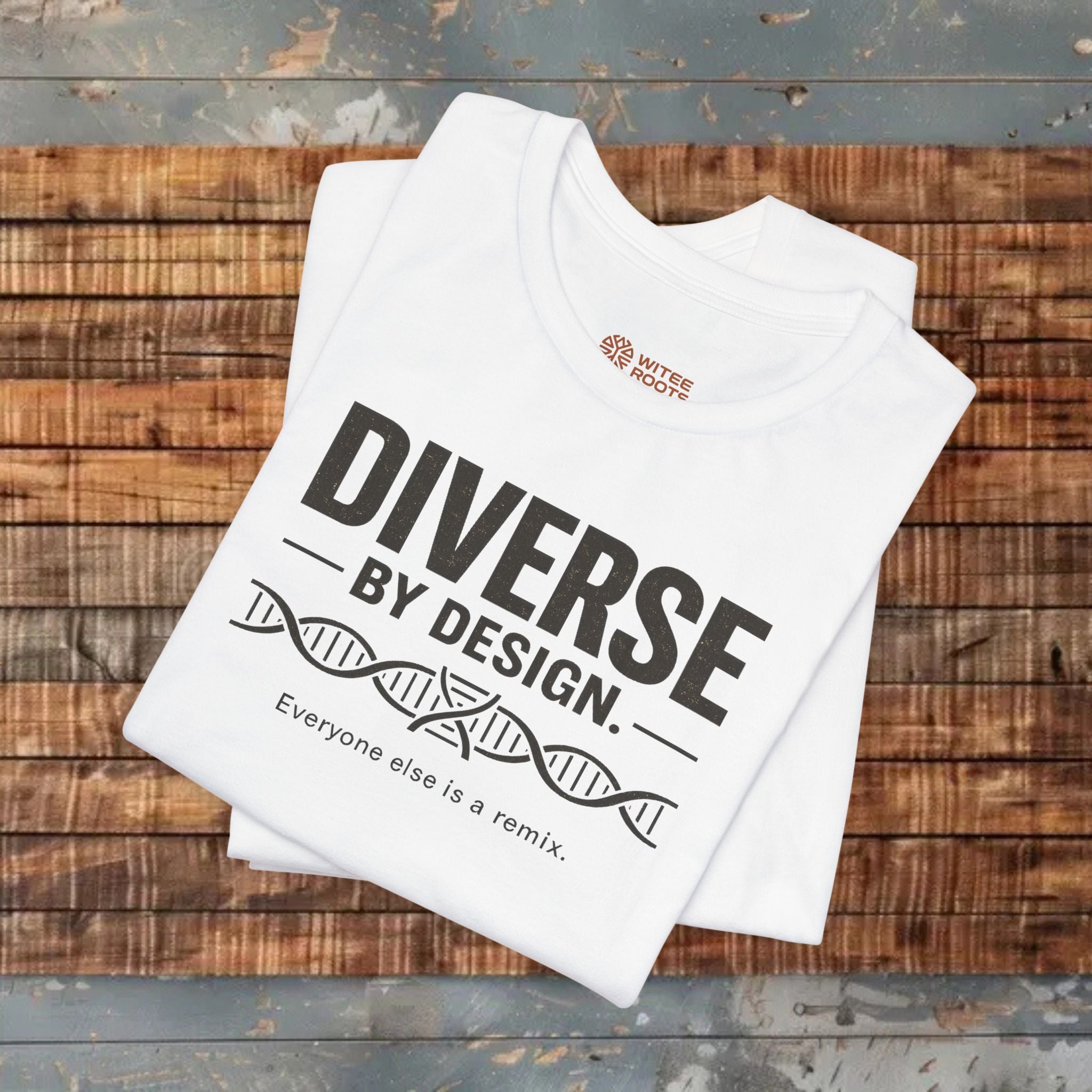 White t-shirt with 'Diverse by Design' text on a wooden surface