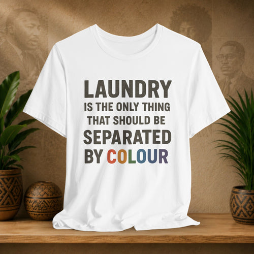 White t-shirt with humorous text design on a wooden surface with plants and decorative items.