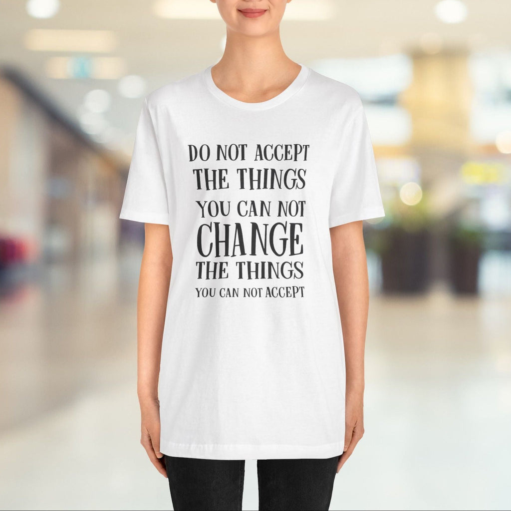 Person wearing a white t-shirt with a motivational quote in a blurred indoor setting