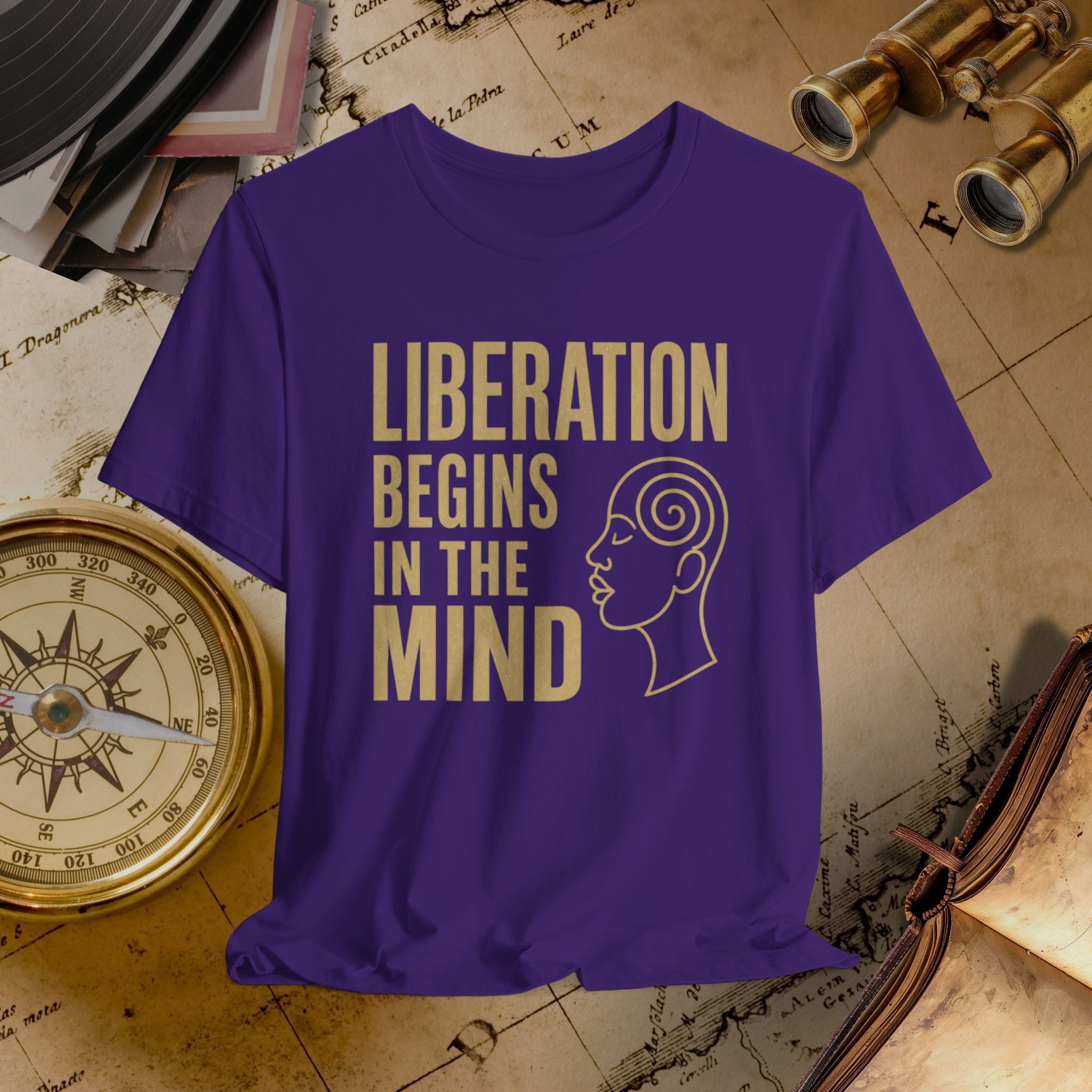 Purple t-shirt with 'Liberation Begins in the Mind' text and a woman's profile on a vintage map background.