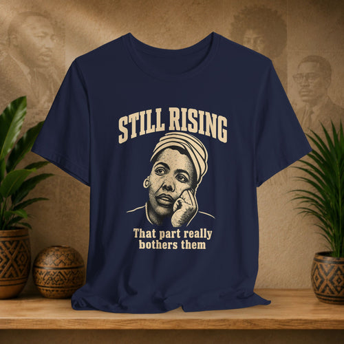 Navy t-shirt with graphic and text on a wooden surface with plants and a textured wall background
