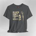 Gray t-shirt with graphic of a person raising a fist and text 'BLACK DON'T CRACK IT RESISTS' on a gray background