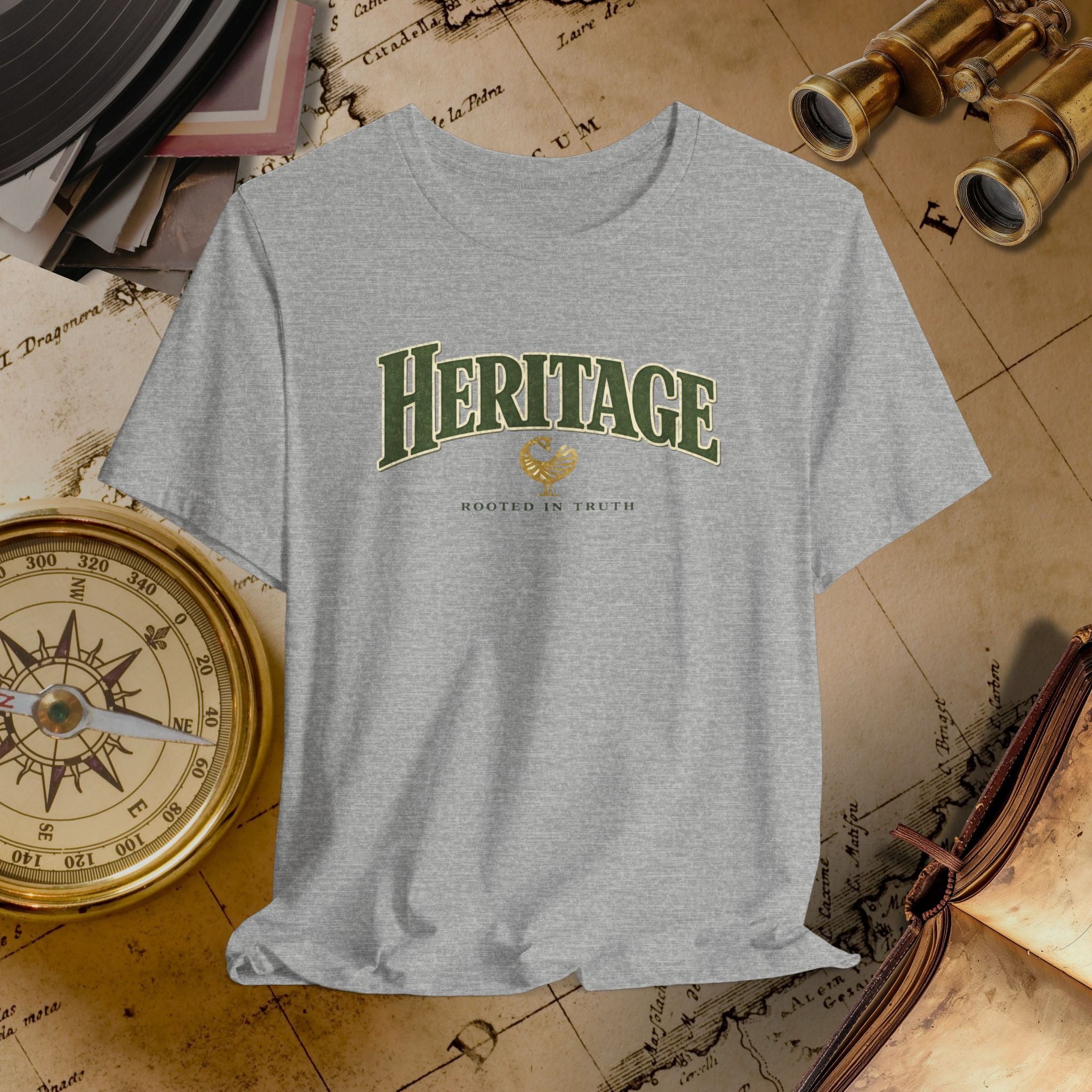 Gray t-shirt with 'HERITAGE' printed on it, placed on a vintage map background.