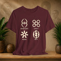 Maroon t-shirt with symbols and text on a wooden surface with plants and a textured wall background