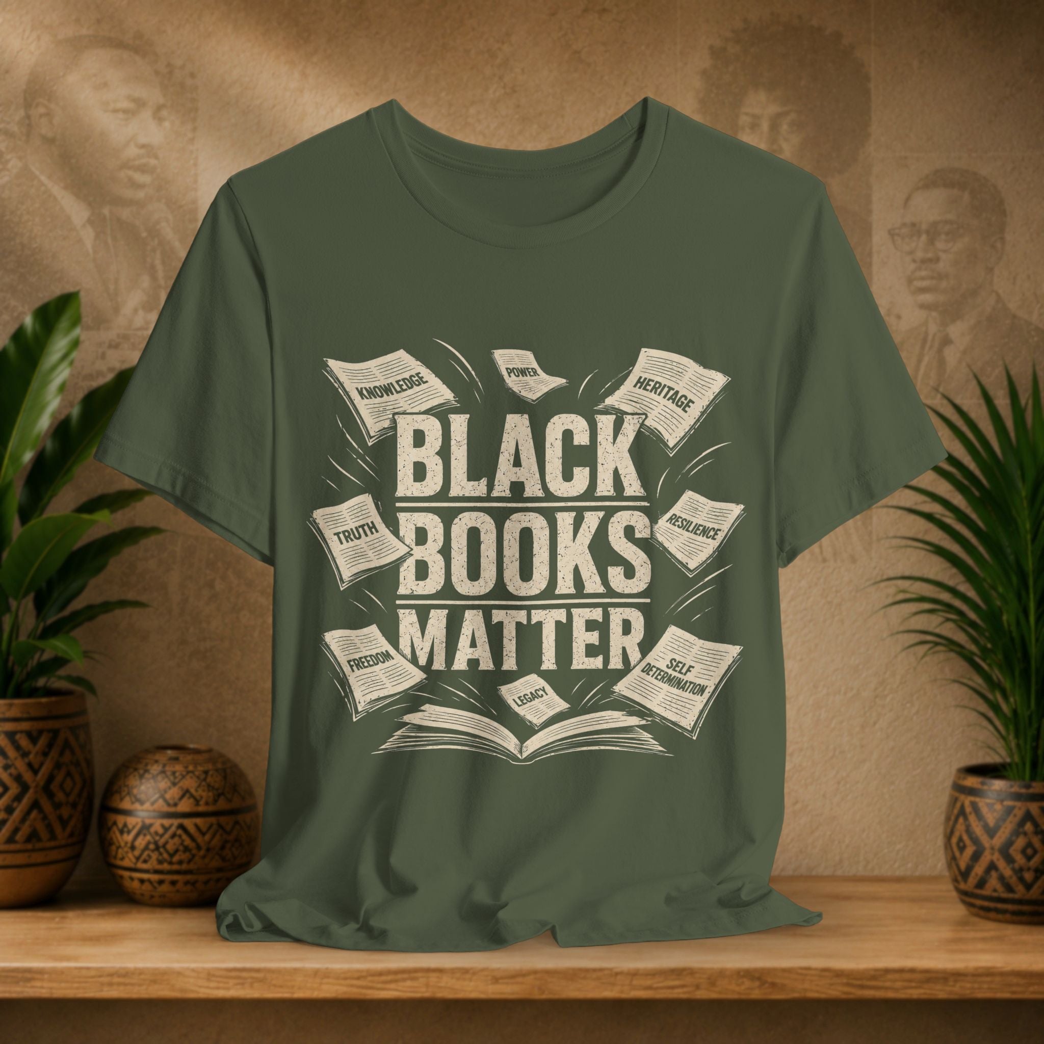 Green t-shirt with 'Black Books Matter' design on a wooden surface with plants and a textured wall in the background.