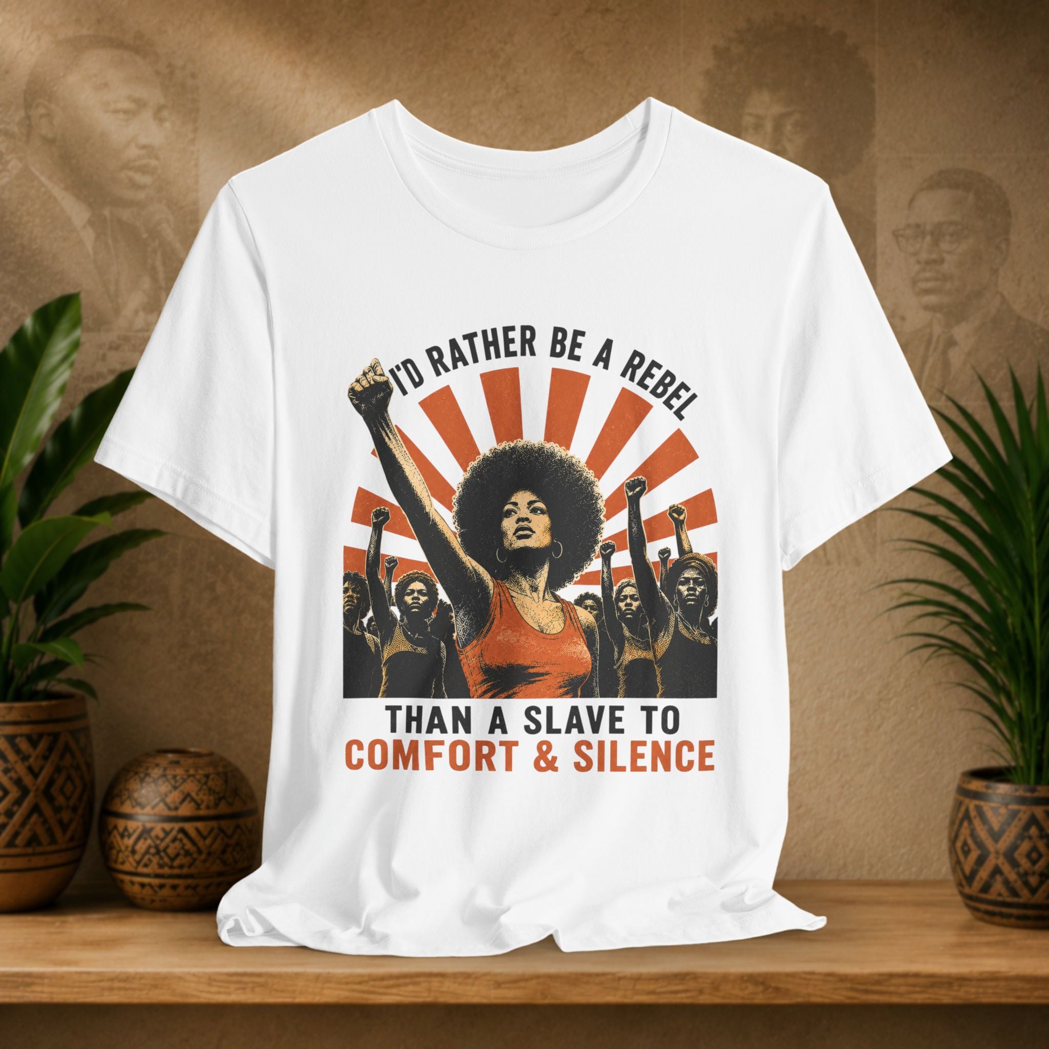 White t-shirt with graphic design featuring a woman with raised fist and text on a wooden surface with plants.