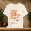 Beige t-shirt with Ray Charles quote on a wooden shelf with plants and decorative items.