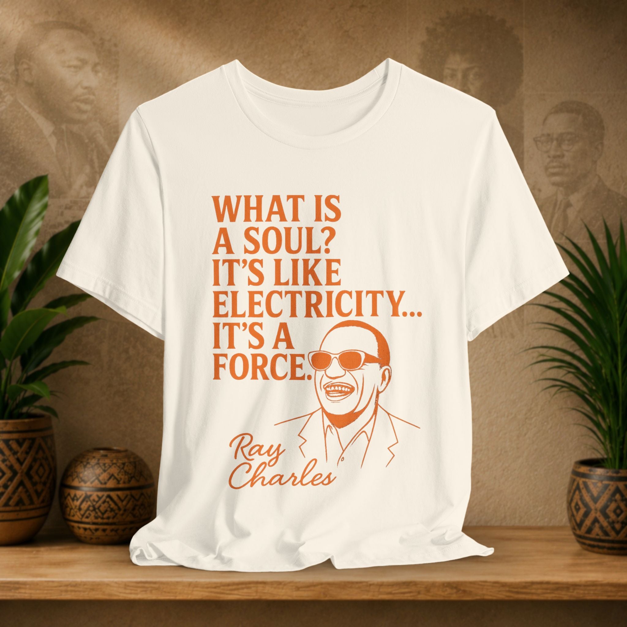 Beige t-shirt with Ray Charles quote on a wooden shelf with plants and decorative items.