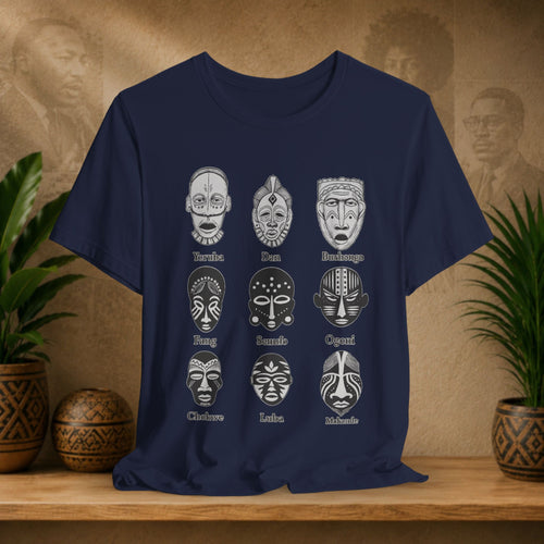 Navy blue t-shirt with white tribal mask designs on a wooden surface with plants and decorative items.