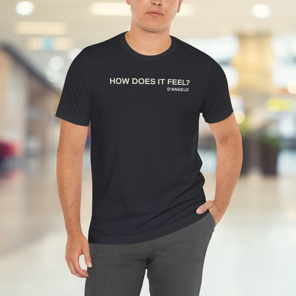 Man wearing a black t-shirt with text in a blurred indoor setting