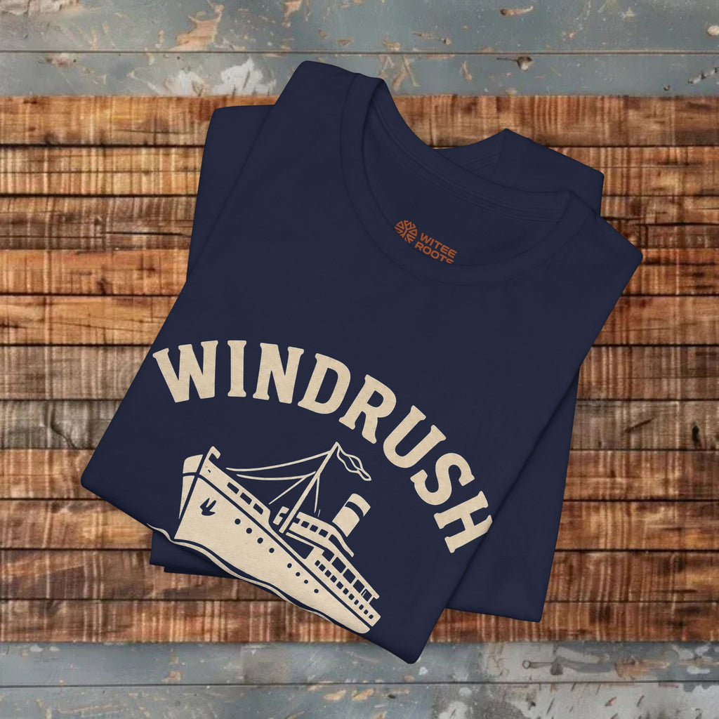 Folded navy blue t-shirt with 'Windrush' design on a wooden surface