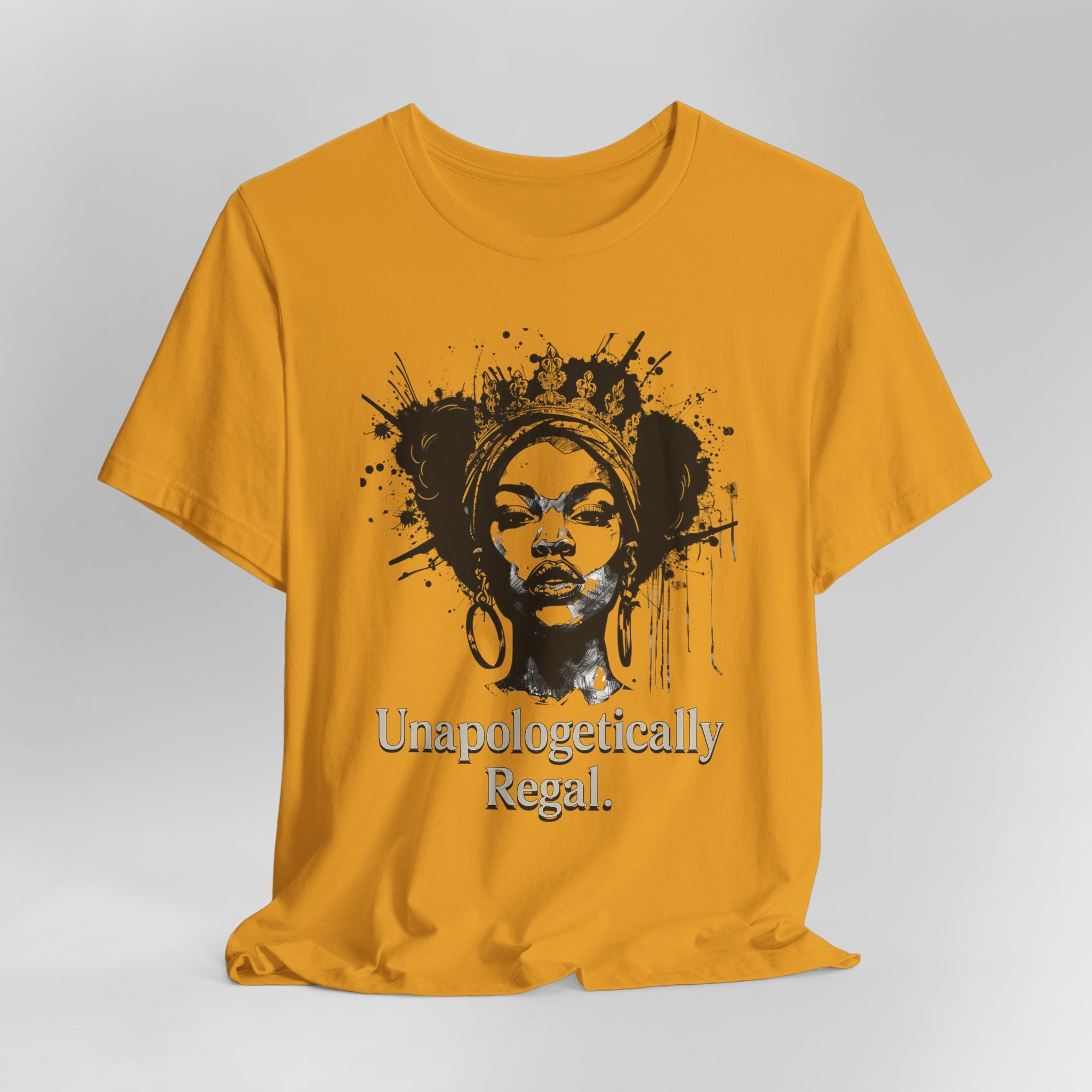 Yellow t-shirt with black graphic and text 'Unapologetically Regal' on a gray background