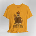 A mustard yellow t-shirt with a Halloween graphic of a ghost in a paisley pattern wearing a pumpkin head and holding a pumpkin spice latte and a bucket labeled 'Jollof Rice'. Below the graphic, the text 'PUMPKIN SPICE & JOLLOF RICE' is printed in black.