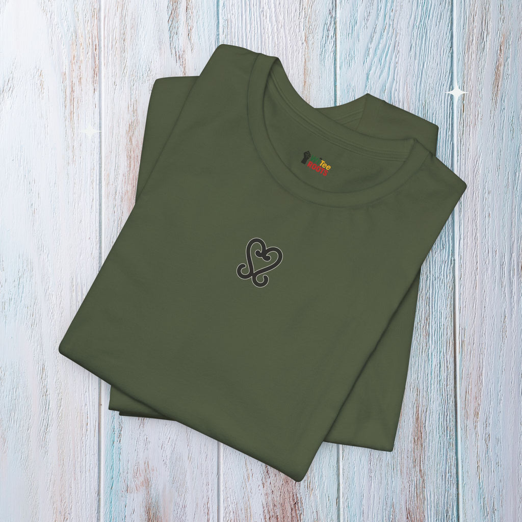 Folded green t-shirt with a heart design on a wooden surface