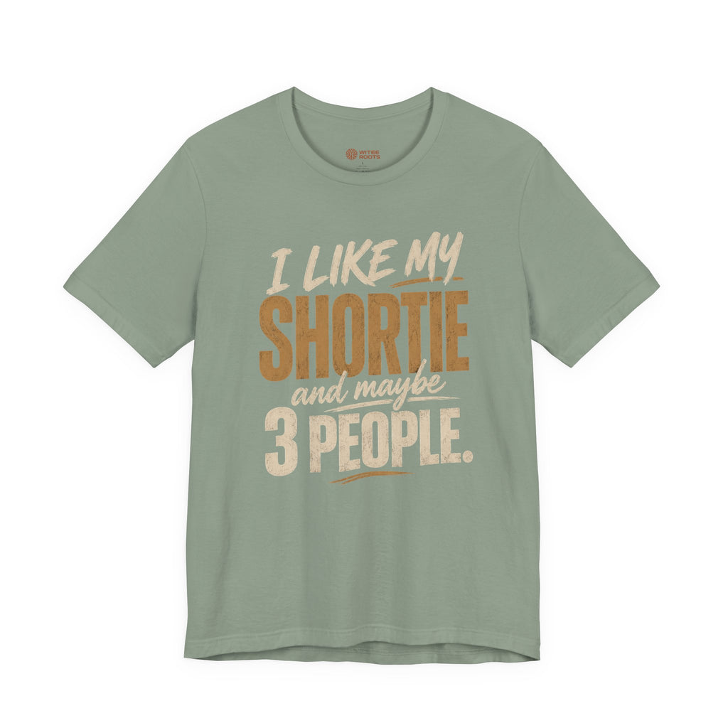 A sage graphic t-shirt displayed on a white background. The shirt features a humorous slogan printed in white and tan lettering: 'I LIKE MY SHORTIE and maybe 3 PEOPLE.