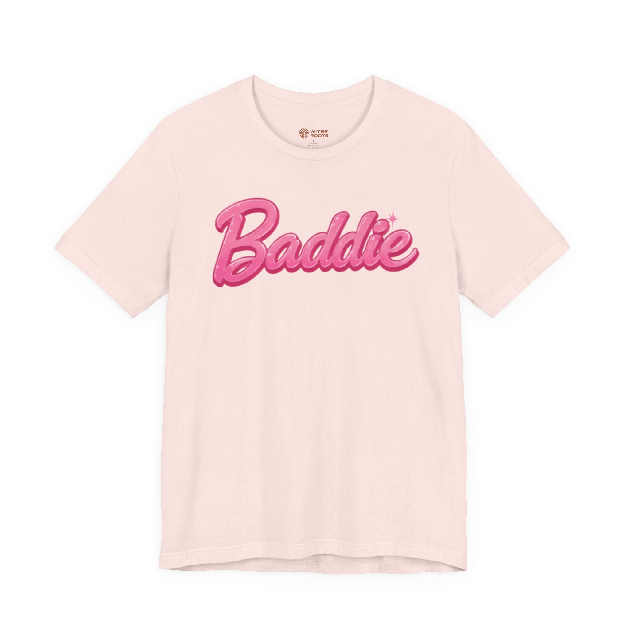 A light pink short-sleeve t-shirt with 'Baddie' printed across the chest in a bold pink cursive font with a small sparkle accent, displayed on a clean white background.