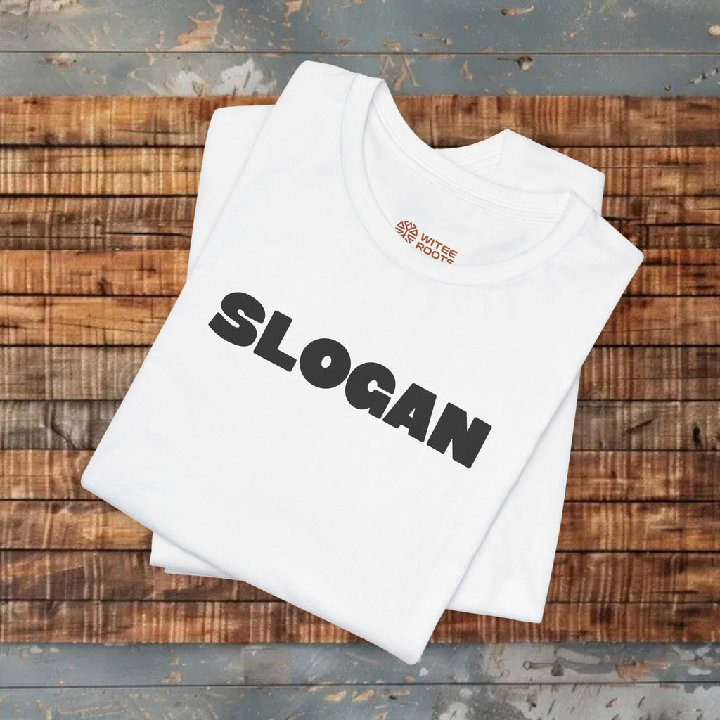 A folded white t-shirt with the word 'SLOGAN' printed in large black letters across the front, displayed on a rustic wooden plank surface.