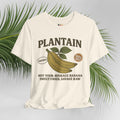 Cream t-shirt with plantain graphic and text on a light gray background with green leaves.
