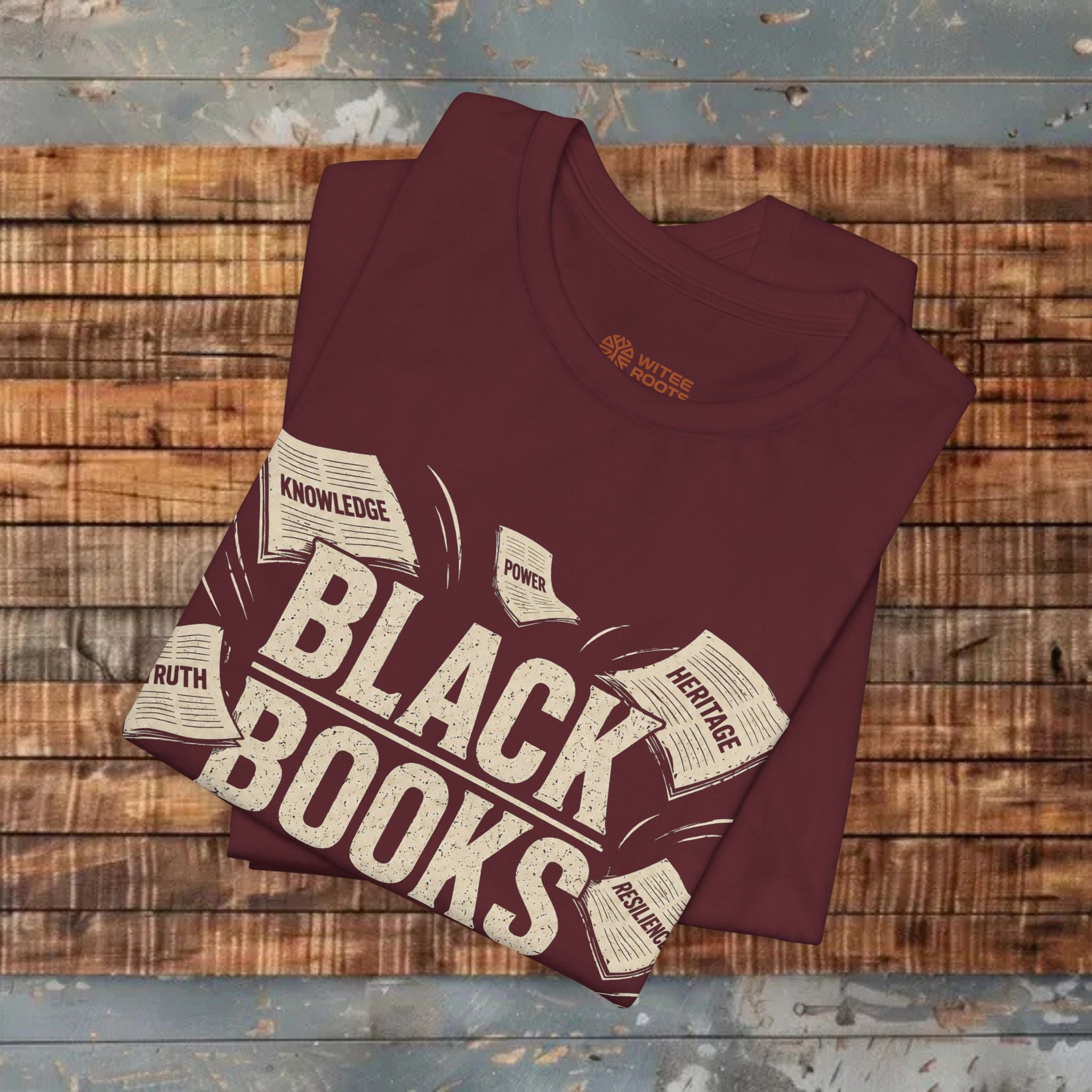 Maroon t-shirt with 'Black Books' design on a wooden surface