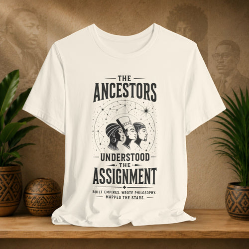 Beige t-shirt with black graphic design on a wooden surface with plants and a brown background