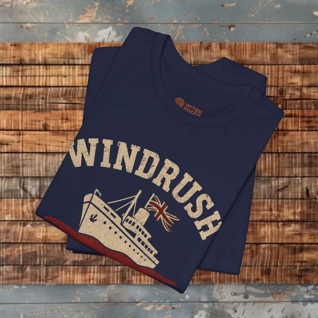 Folded navy blue t-shirt with 'Windrush' design on a wooden surface