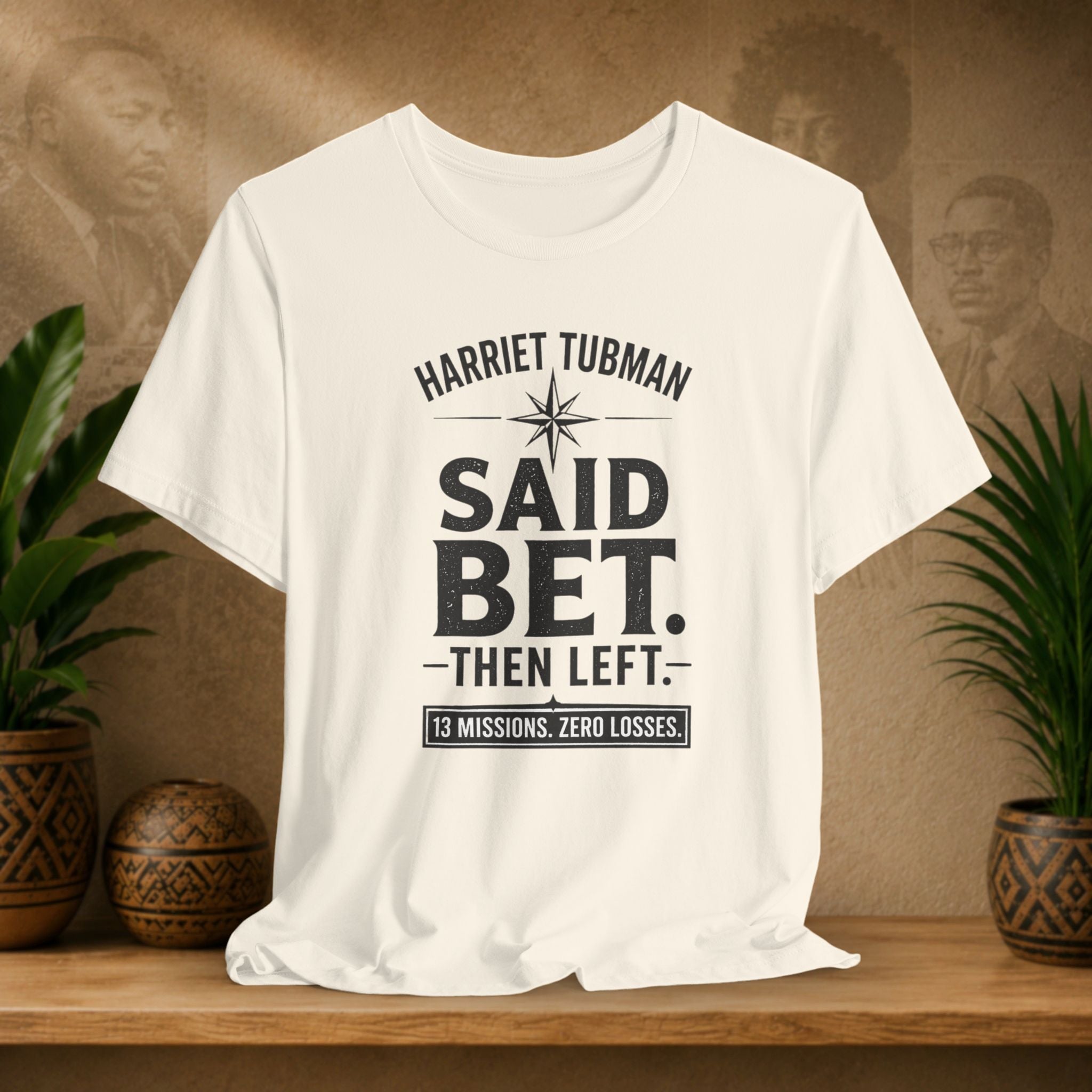 Beige t-shirt with text on a wooden surface with plants and a decorative item in the background