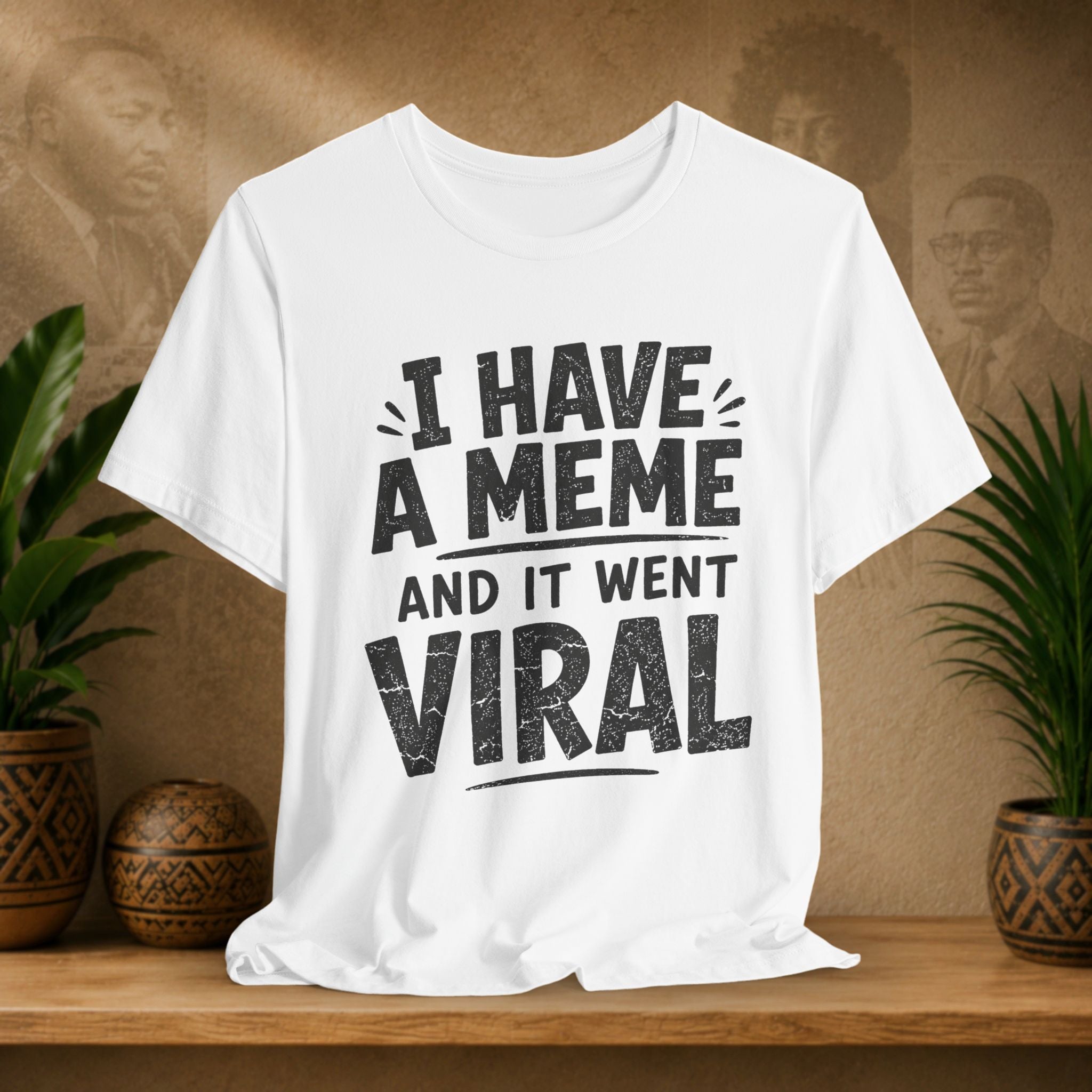 White t-shirt with text 'I HAVE A MEME AND IT WENT VIRAL' on a wooden surface with a decorative background.