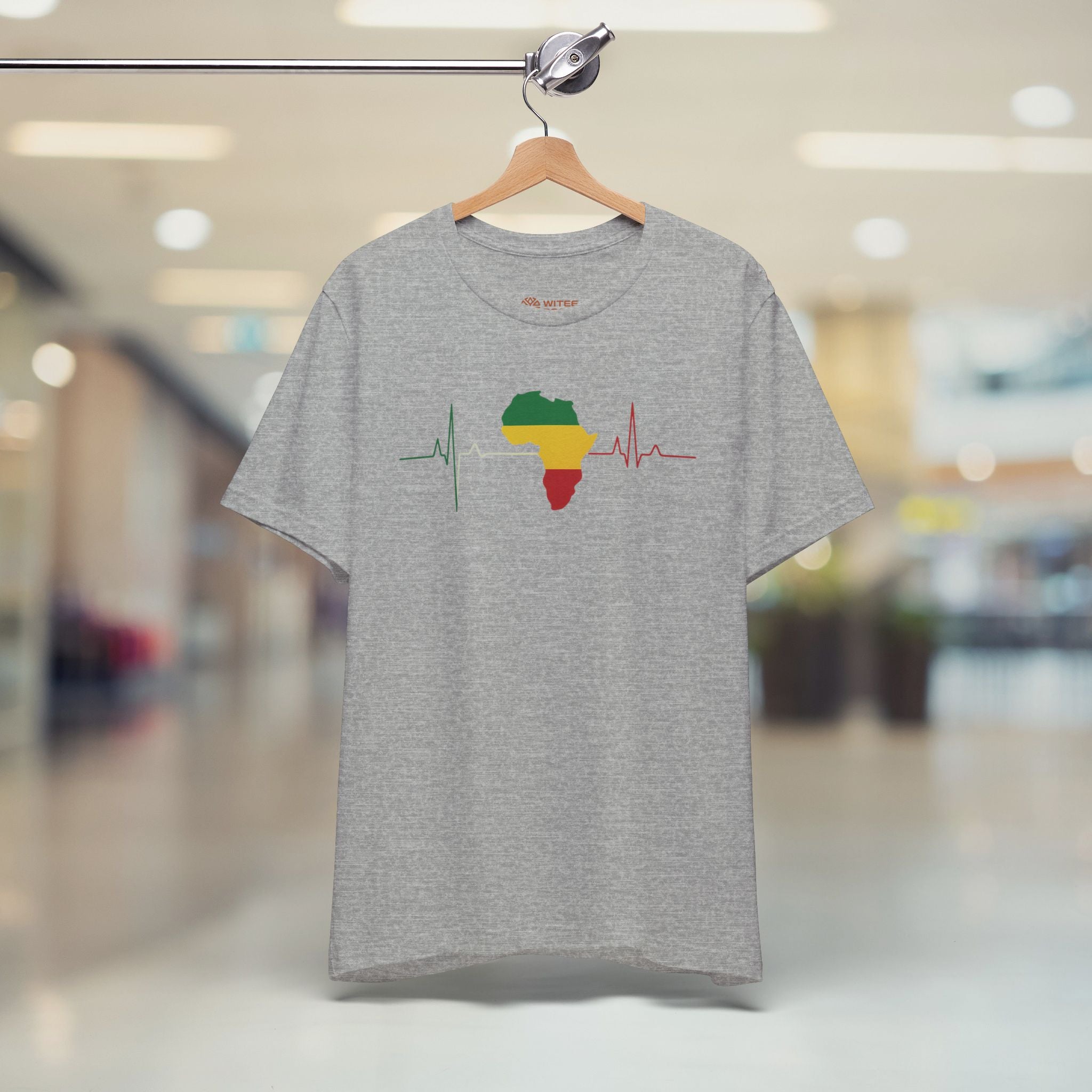 Gray t-shirt with a colorful design on a hanger in a store setting
