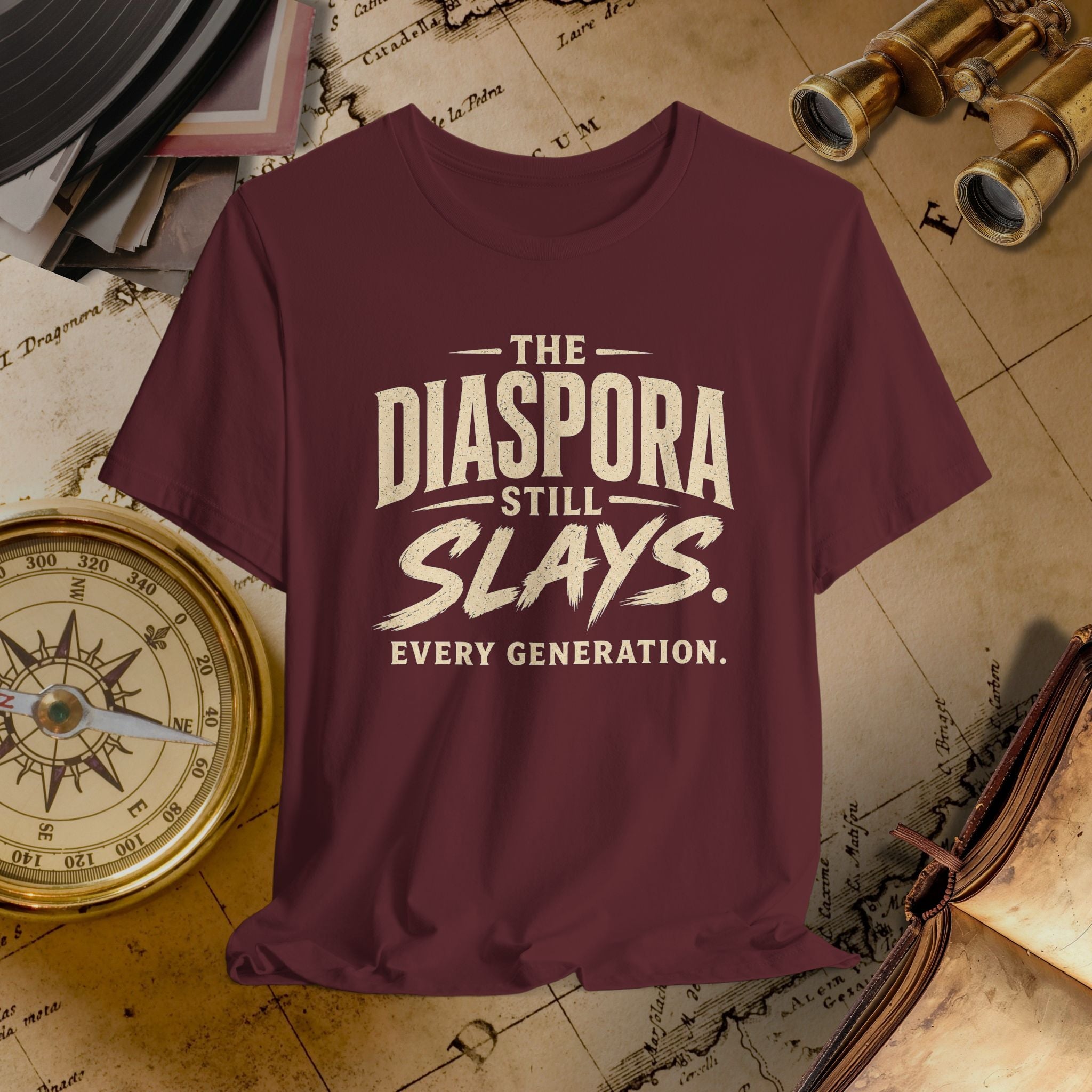 Maroon t-shirt with 'The Diaspora Still Slays Every Generation' text on a vintage map background.