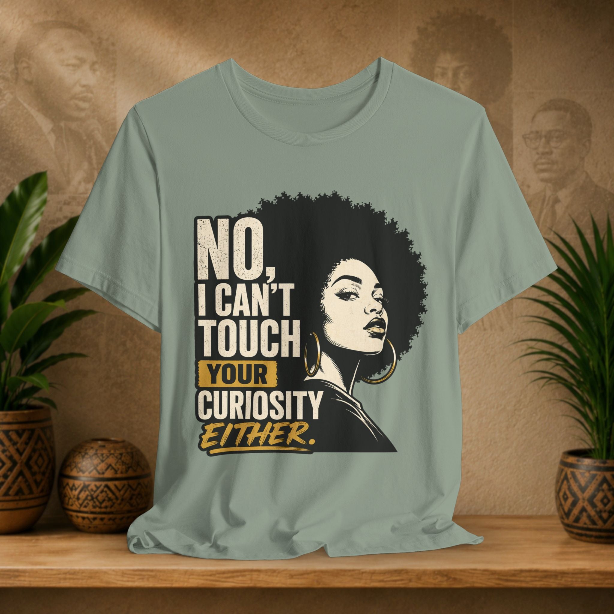 T-shirt with a graphic of a woman with an afro and text on a wooden surface with plants and a decorative item.