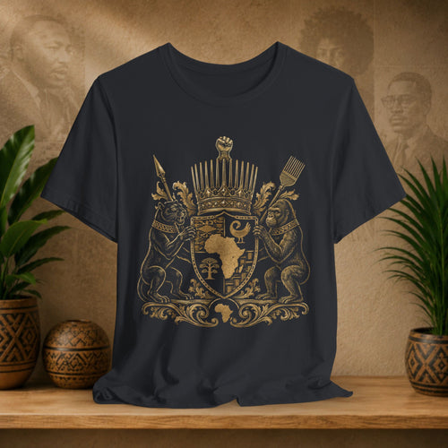 Black t-shirt with gold emblem on a wooden surface with plants and decorative items.