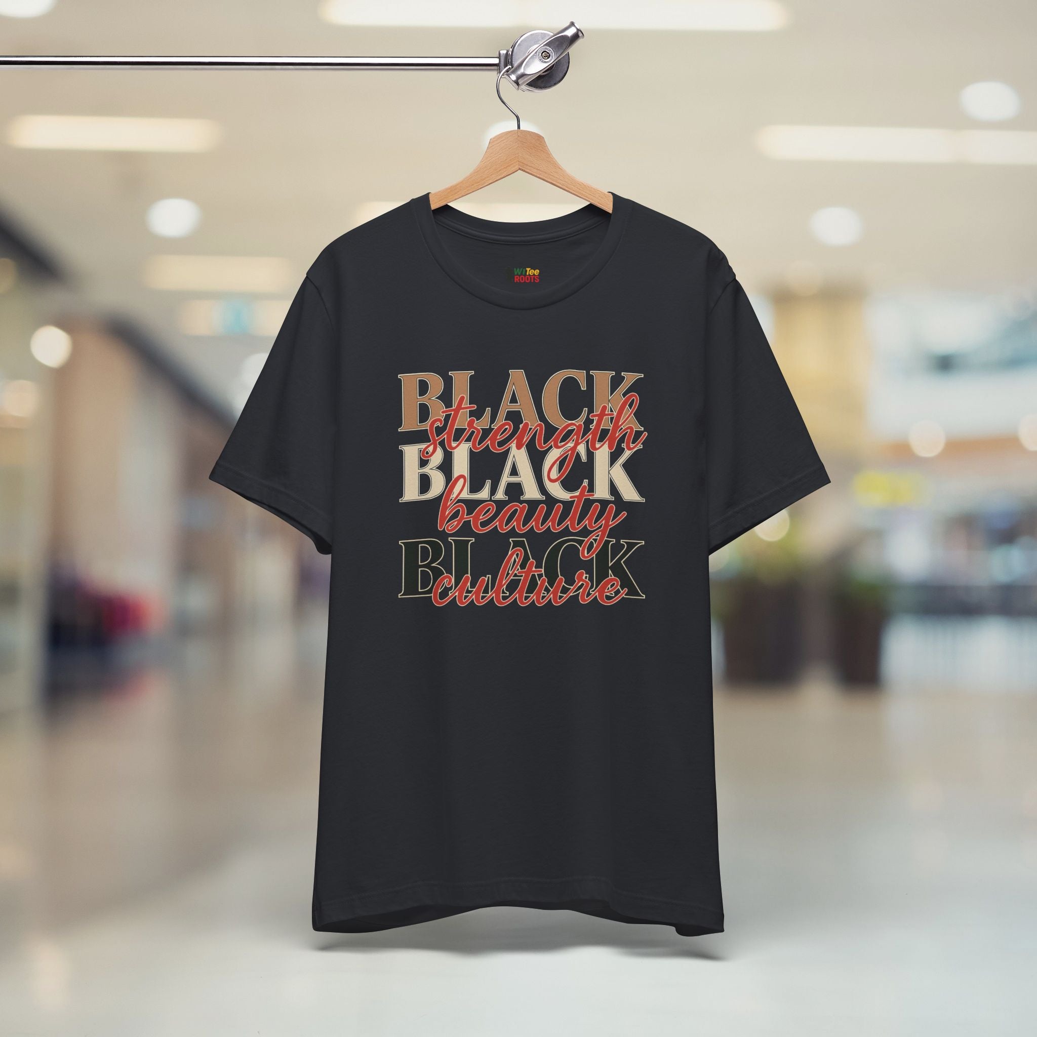 Black t-shirt with 'BLACK strength BLACK beauty culture' text on a hanger in a store.