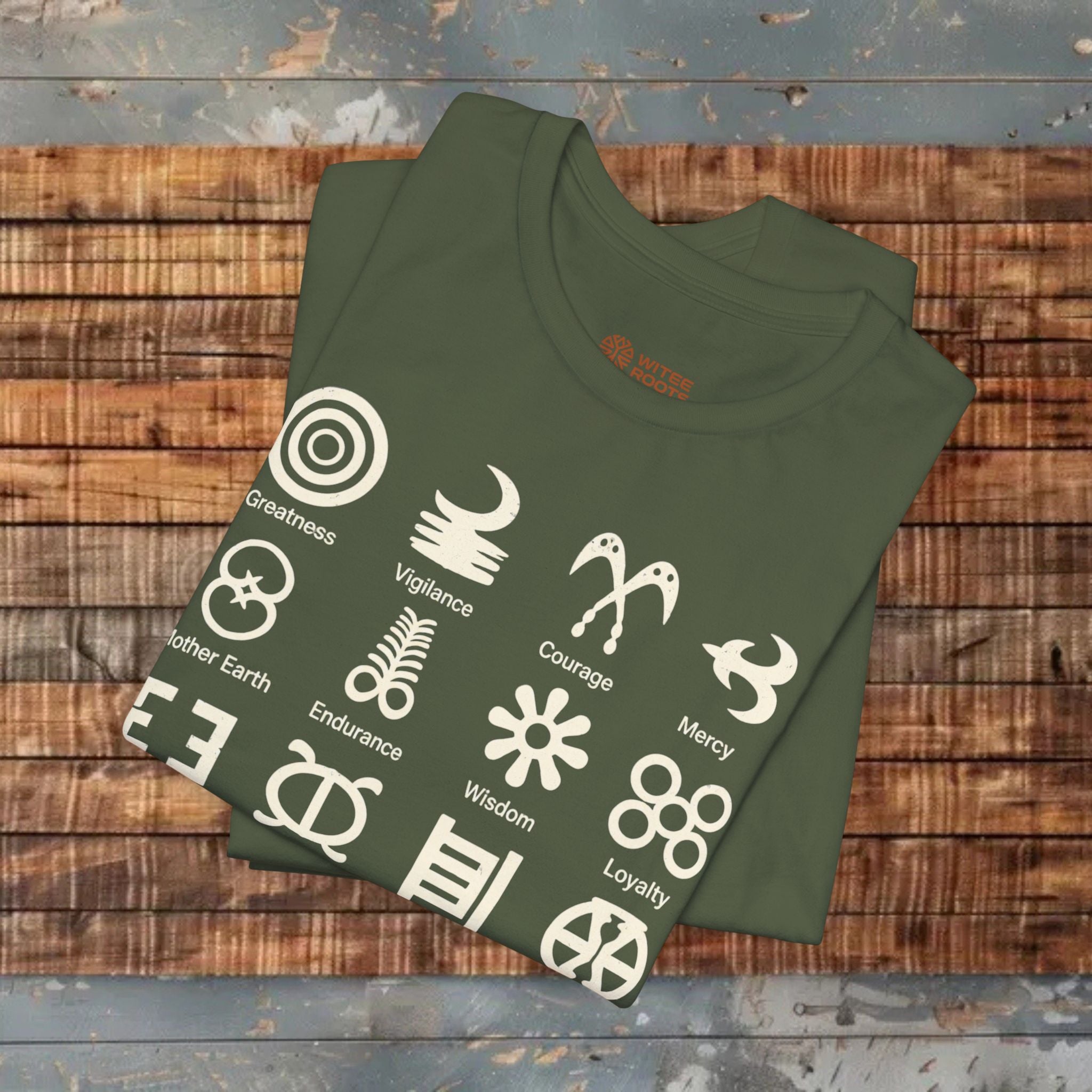 Green t-shirt with white symbols and text on a wooden surface