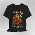 Black t-shirt with a graphic of Santa Claus and an African-American man, text 'HO-HO-HO! AT THE BAR GETTIN' TIPSY' on a gray background.