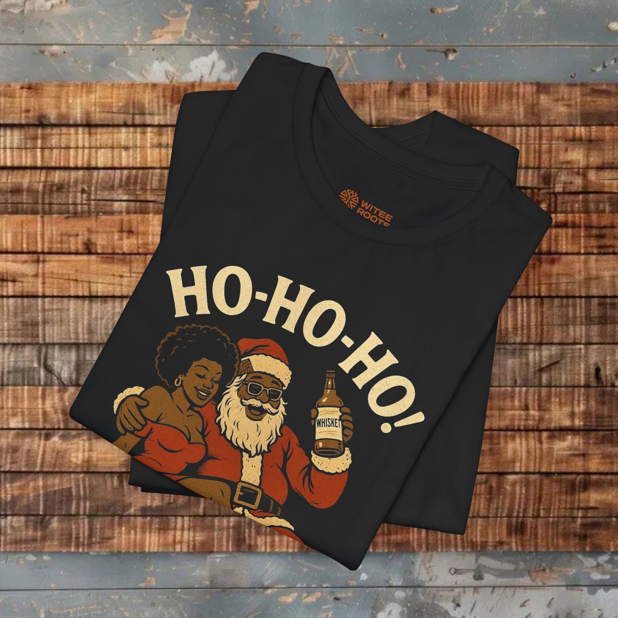 Black t-shirt with a graphic of a person in a Santa Claus outfit and 'HO-HO-HO!' text on a wooden surface.