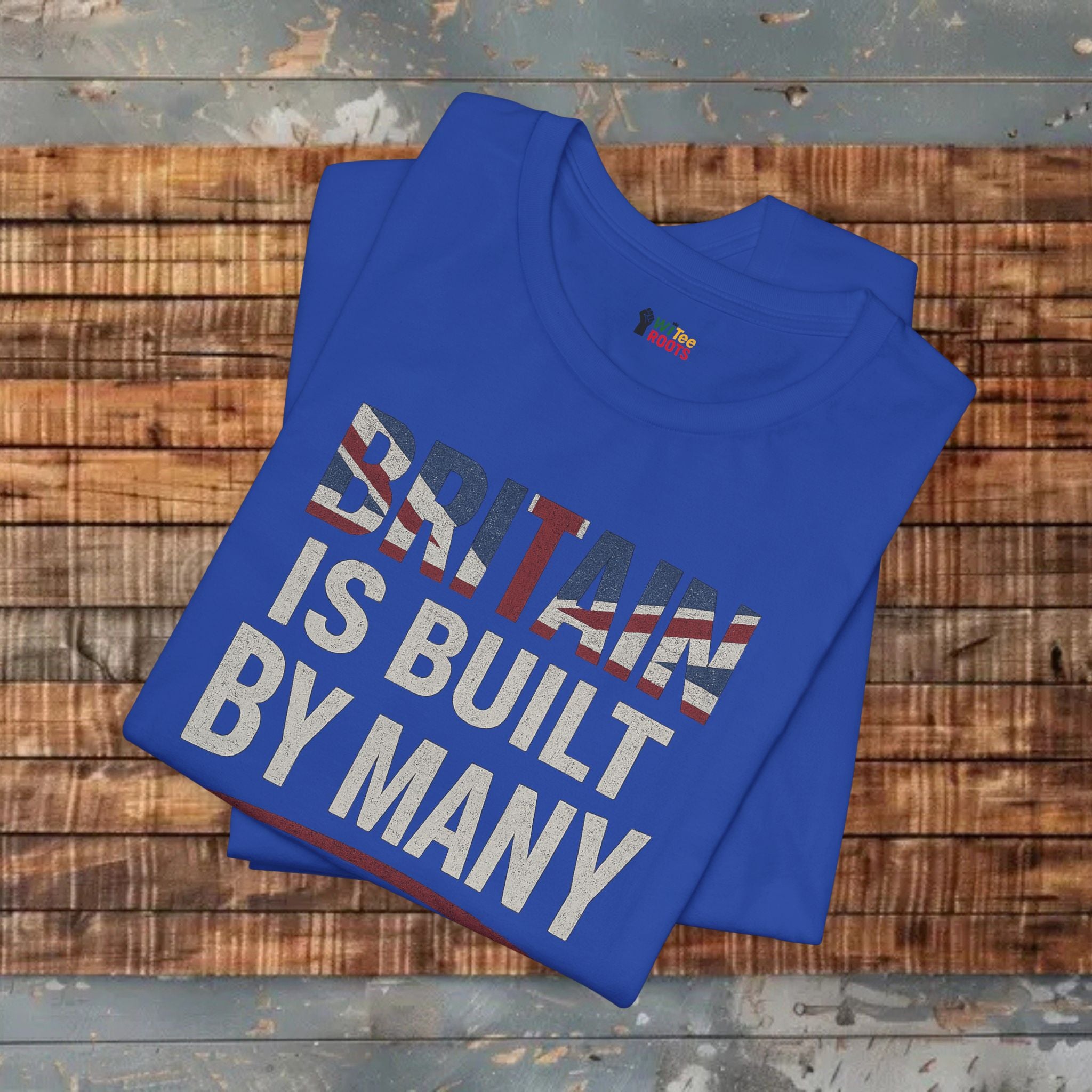 Blue t-shirt with 'Britain is built by many' text on a wooden surface