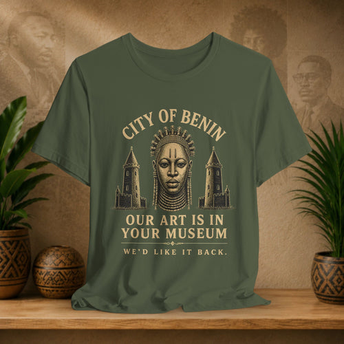 Green t-shirt with graphic design and text on a wooden surface with plants and decorative items.