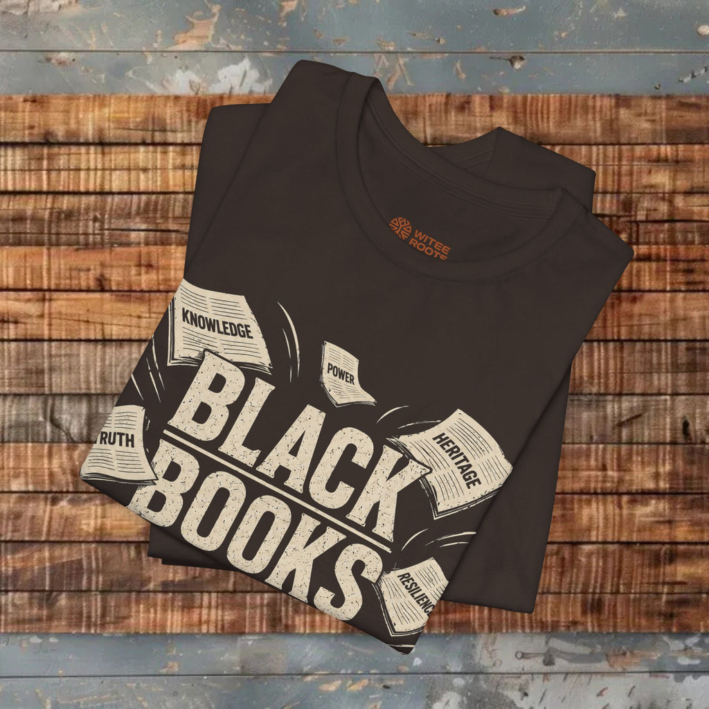 Folded black t-shirt with 'Black Books' design on a wooden surface