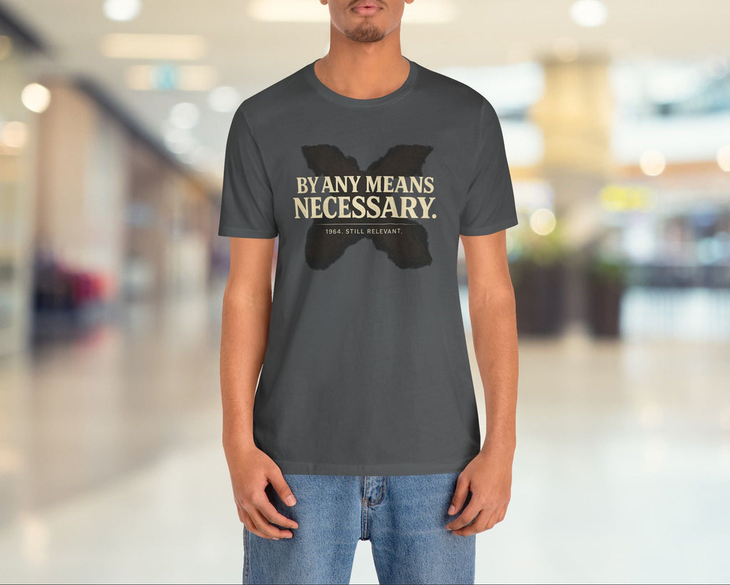 Person wearing a gray t-shirt with text and graphic design in a blurred indoor setting