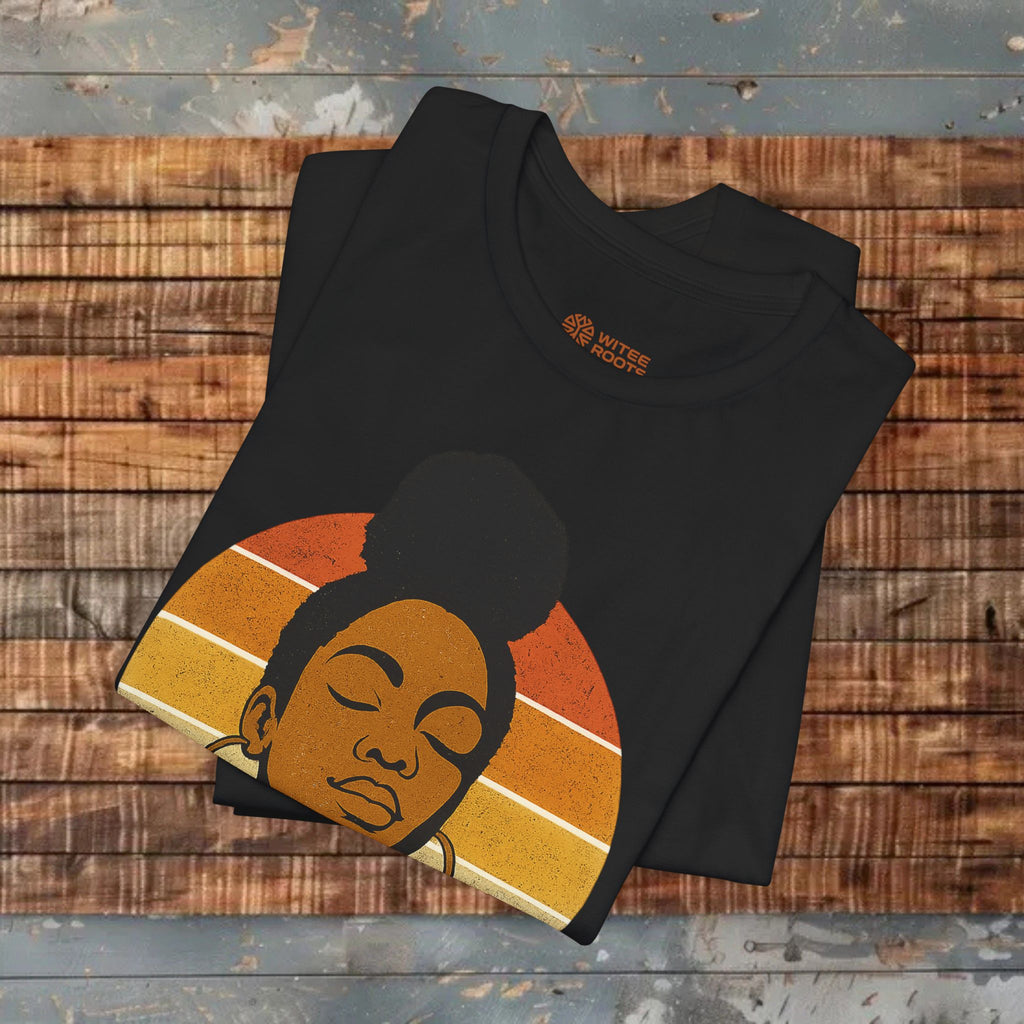 Black t-shirt with a graphic design of a woman's face on a wooden surface