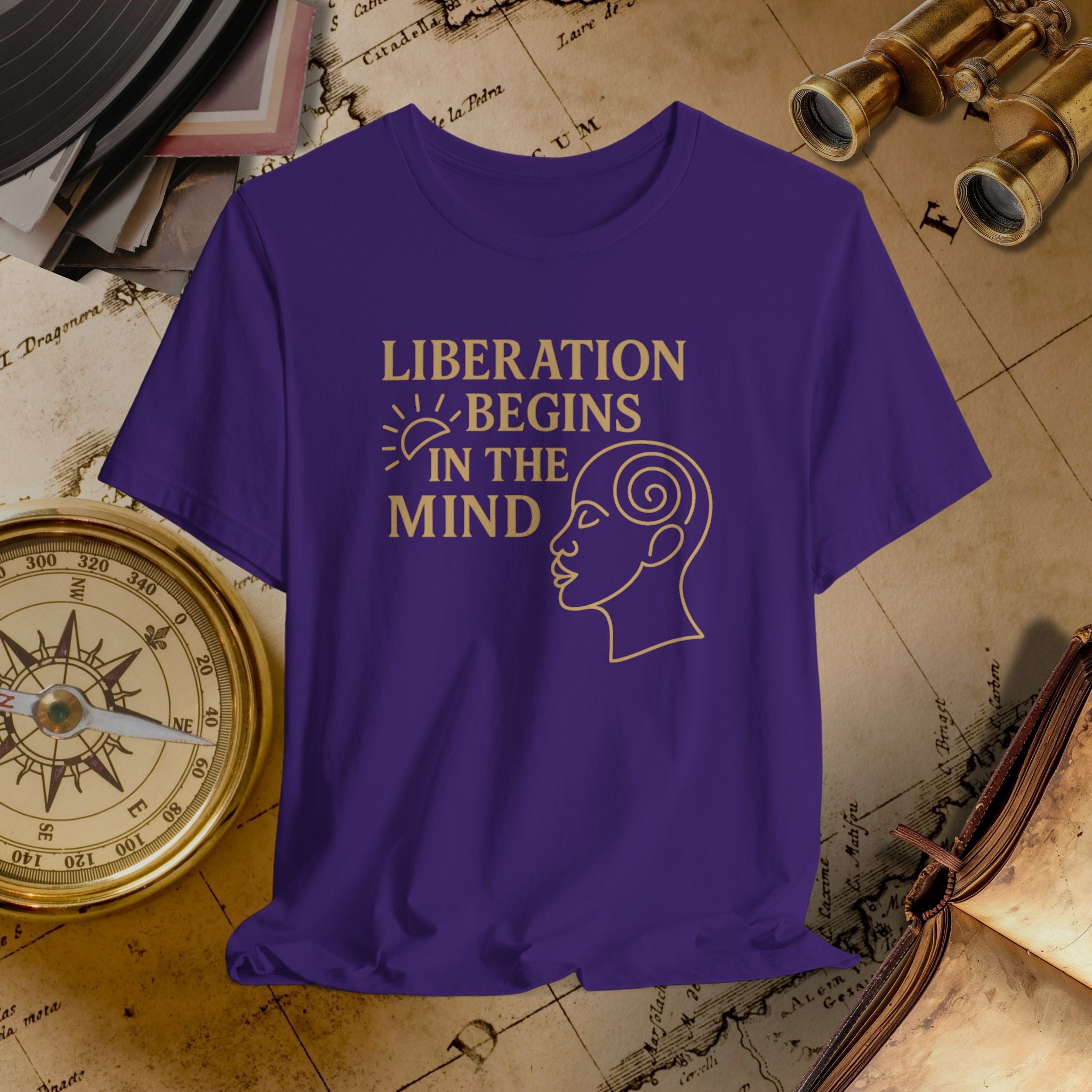 Purple t-shirt with 'Liberation Begins in the Mind' text and graphic on a vintage map background.