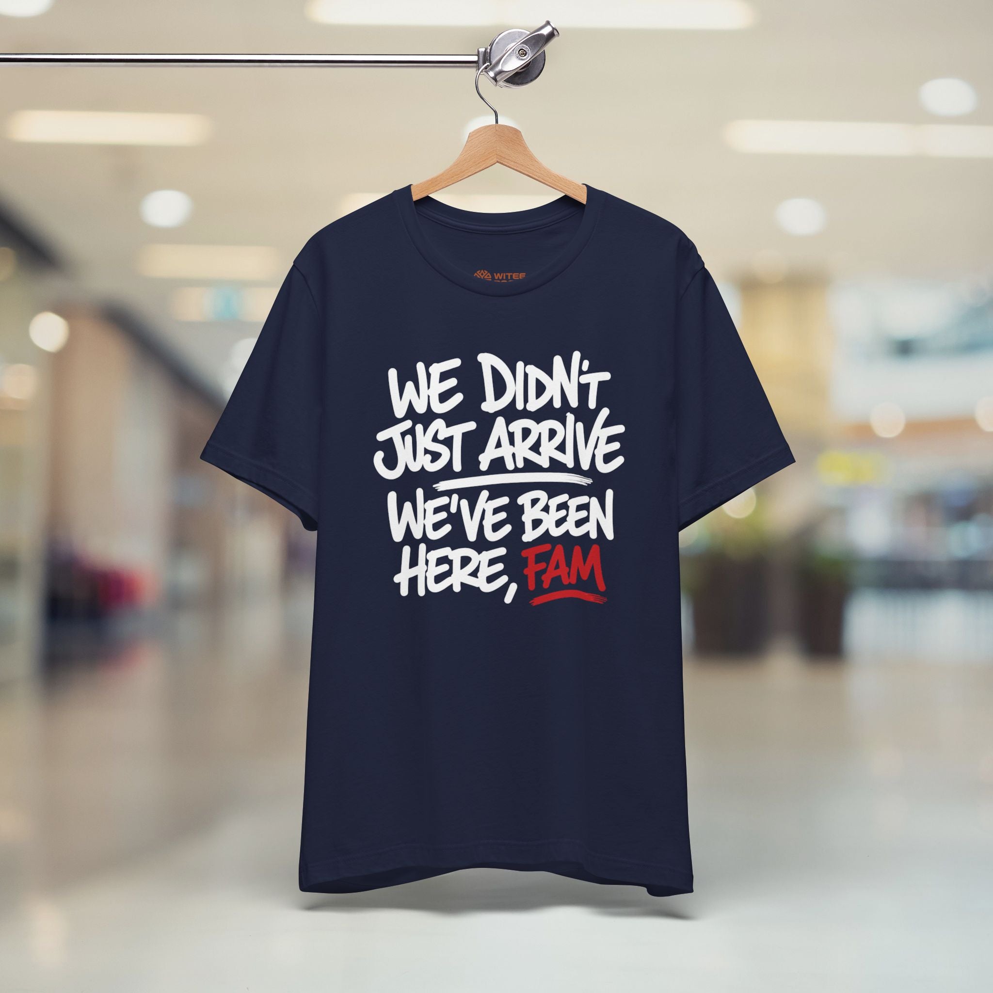 Navy blue t-shirt with humorous text design on a hanger in a store setting