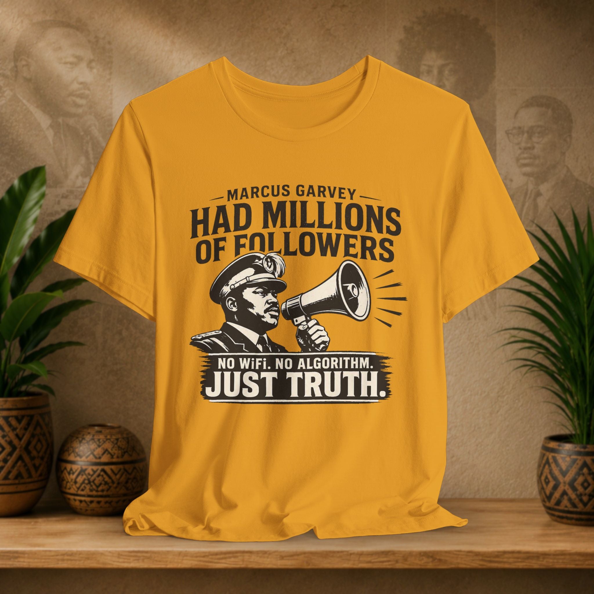 Yellow t-shirt with a graphic and text on a wooden surface with plants and a textured wall in the background