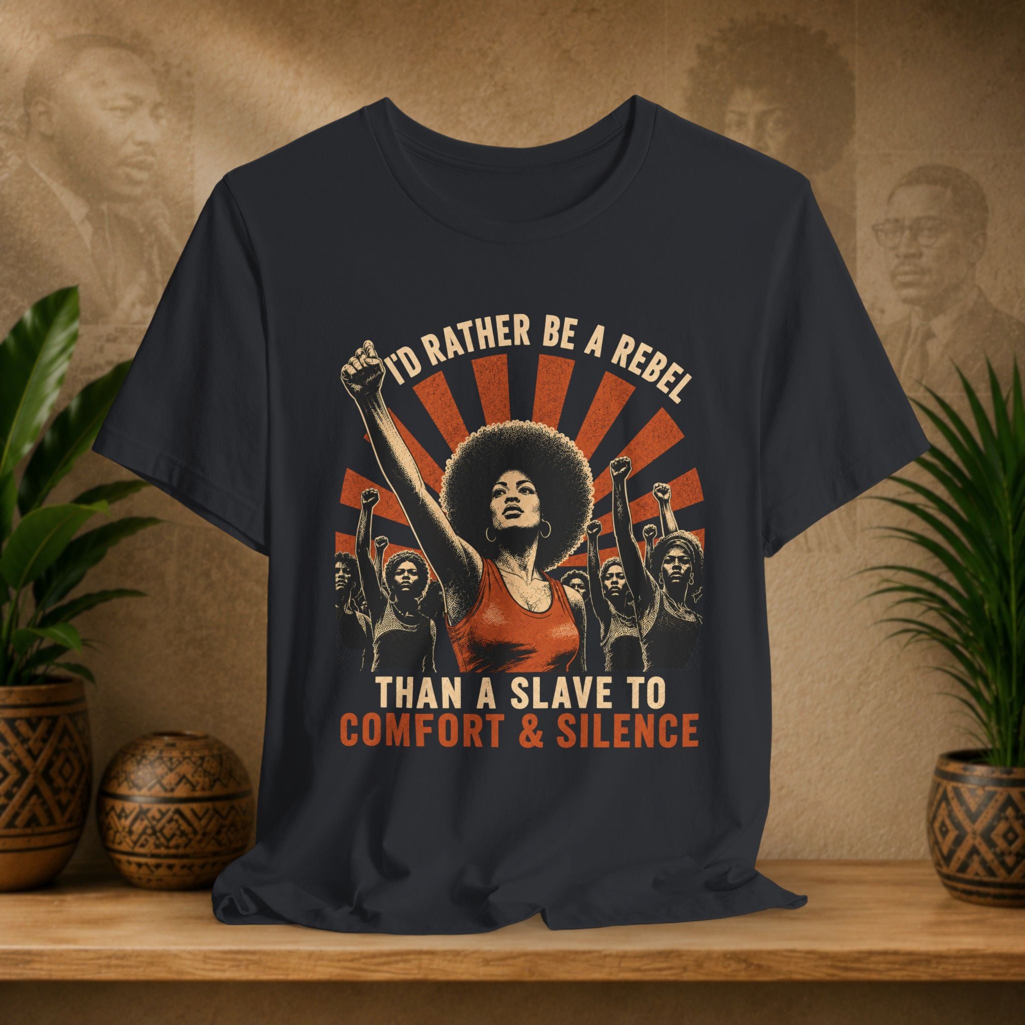 Navy blue t-shirt with graphic design and text on a wooden surface with plants and decorative items.