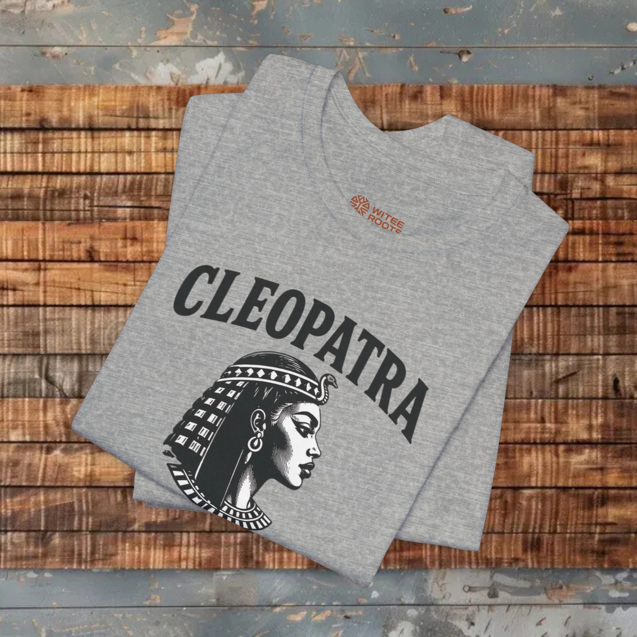 Gray t-shirt with Cleopatra design on a wooden surface