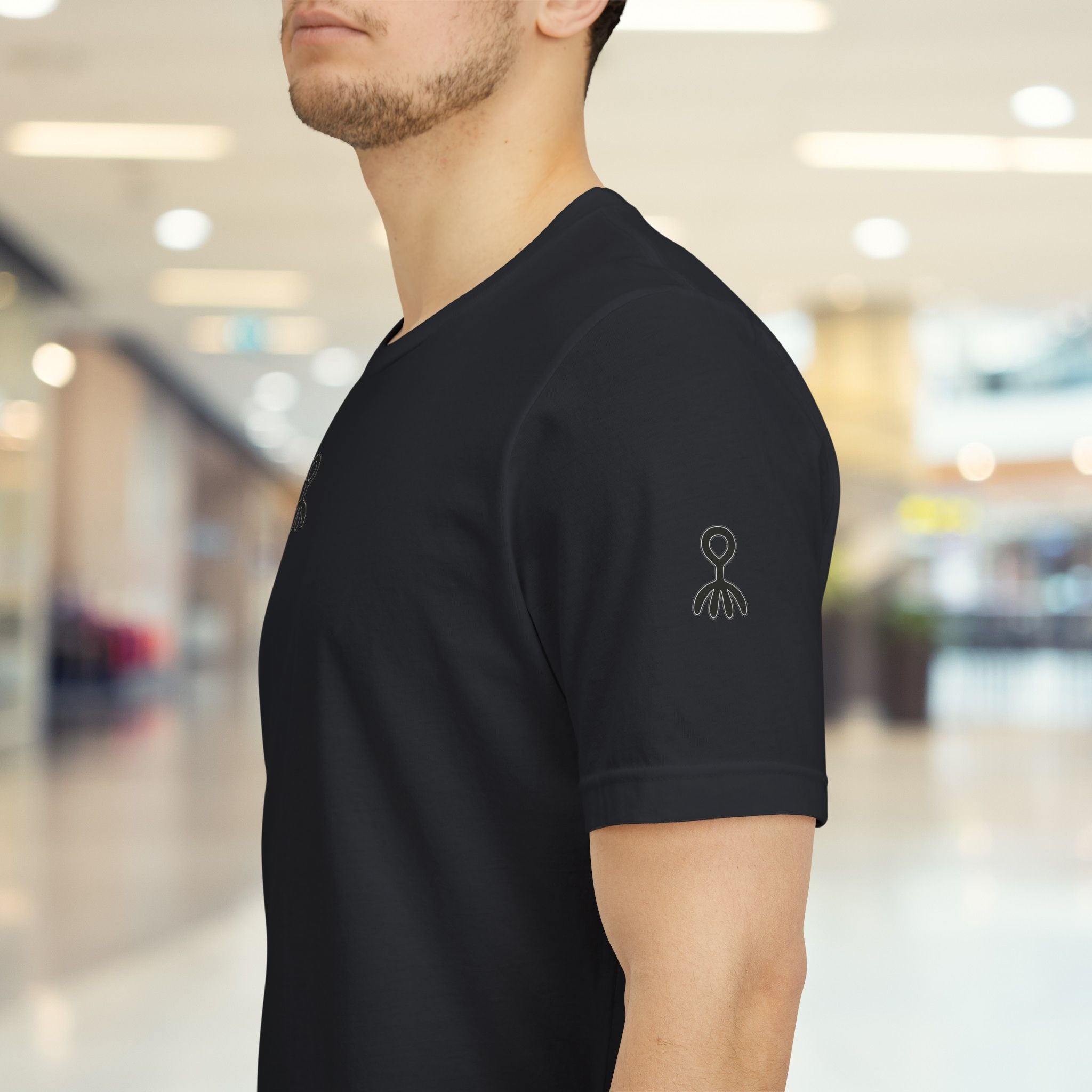 Person wearing a black t-shirt with a logo in an indoor setting