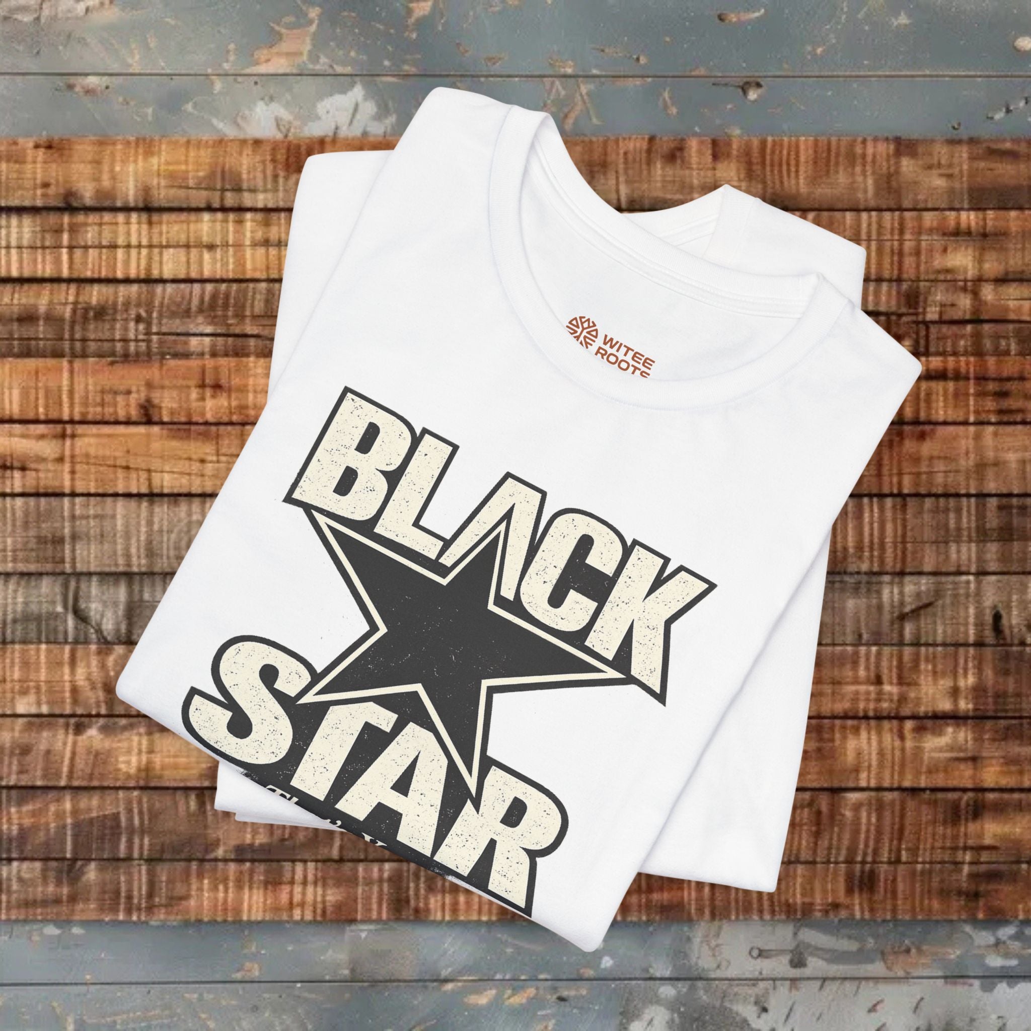 White t-shirt with 'Black Star' design on a wooden surface