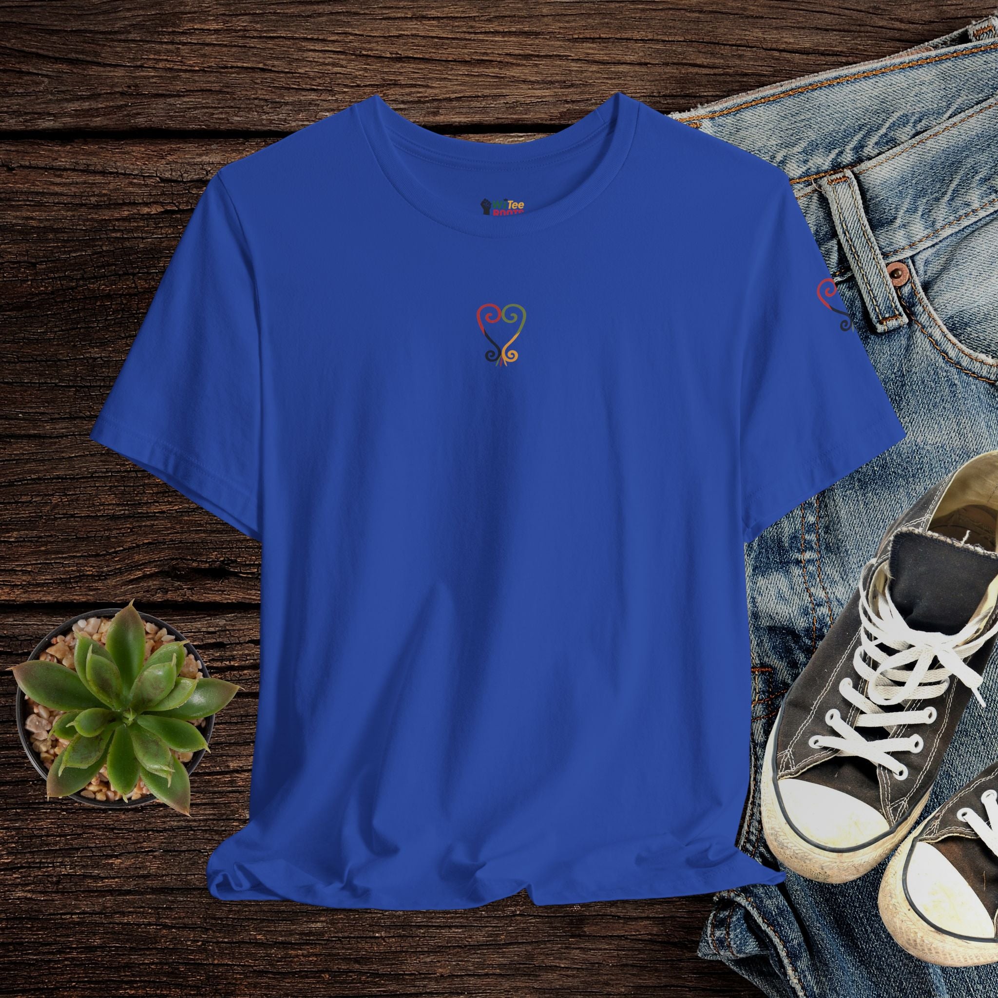 Blue t-shirt with a logo on a wooden surface with jeans and sneakers.