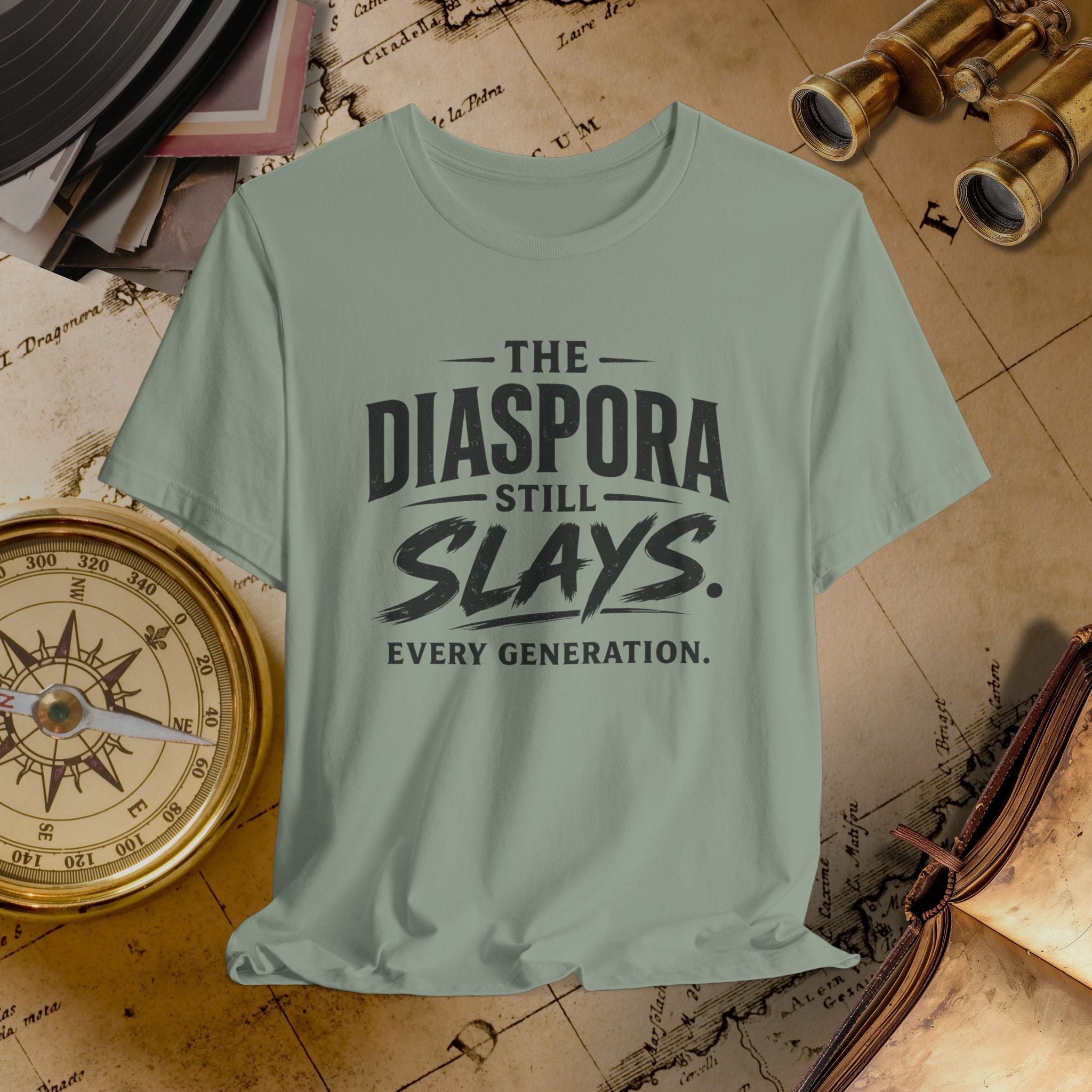 Light green t-shirt with 'The Diaspora Still Slays Every Generation' text on a vintage map background.