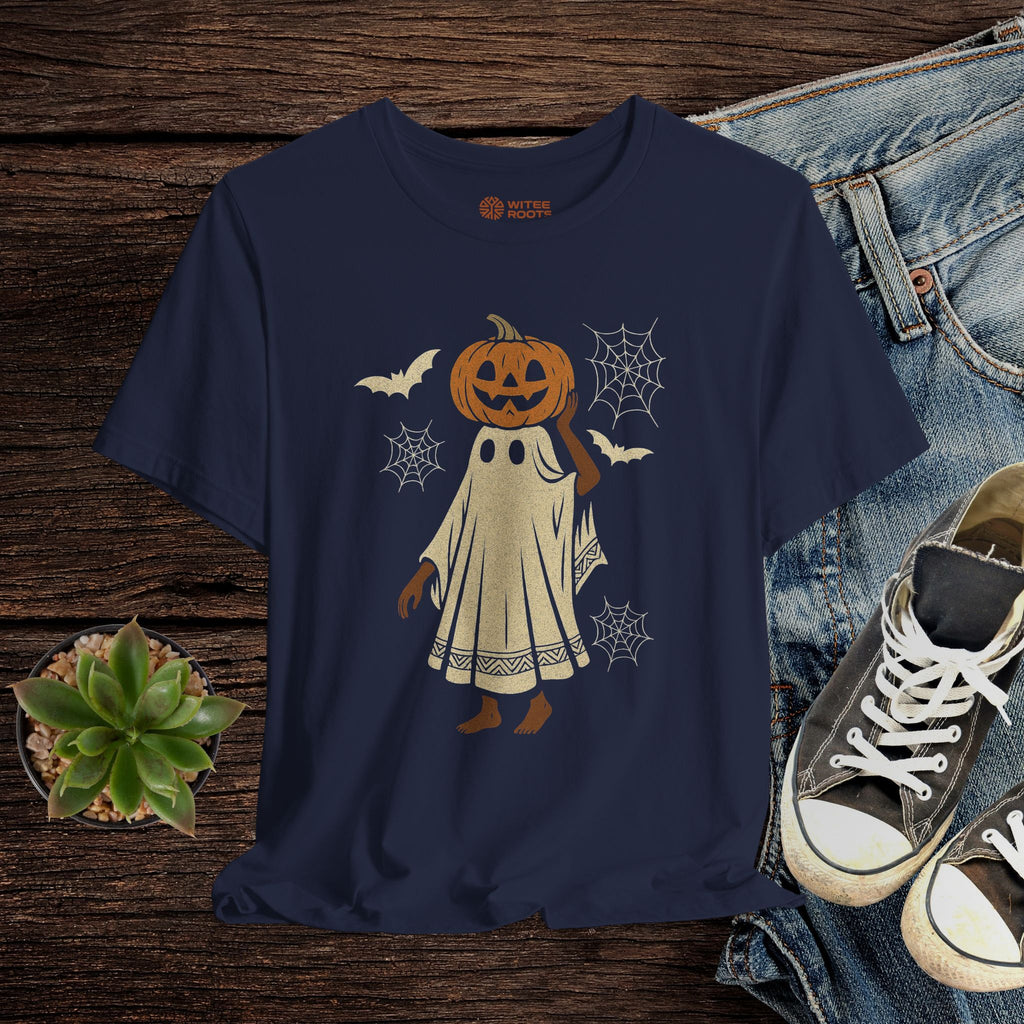 Navy blue t-shirt with Halloween-themed design featuring a pumpkin head and ghost, displayed on a wooden surface with jeans and sneakers.